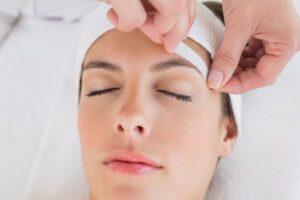 waxing woman's eyebrows
